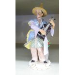 A 20thC German porcelain figure, a standing Chinaman, playing a stringed instrument,