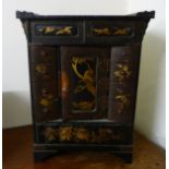 An early 20thC Japanese, black lacquered and gilt painted table cabinet, comprising a central door,