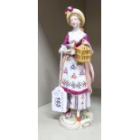 A late 19th/early 20thC Naples porcelain figure, a young woman wearing a floral pinafore dress,