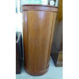 A modern Danish teak pedestal cabinet, the bow front door enclosing four height adjustable shelves,