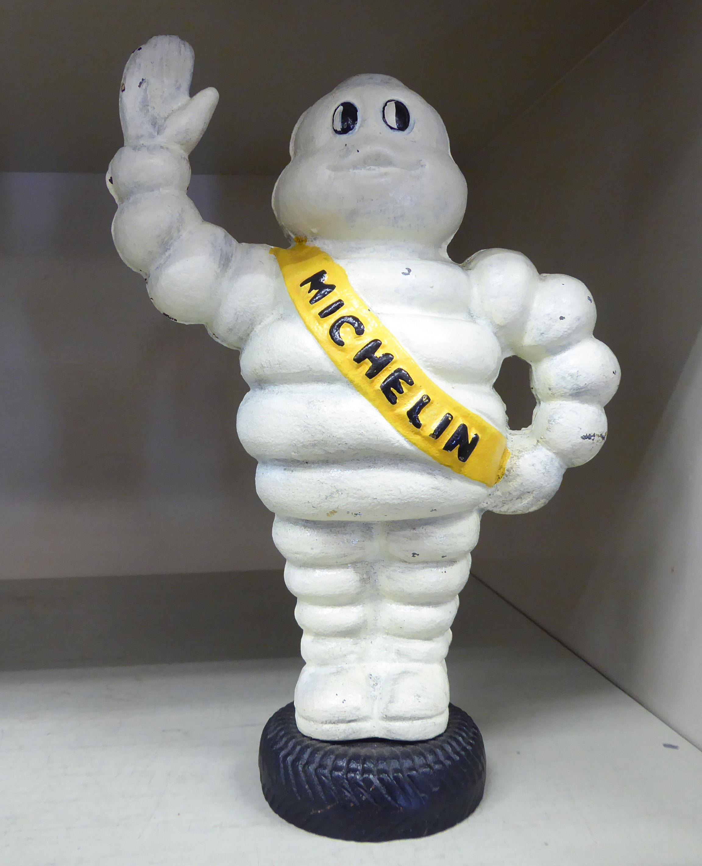 A cast iron model, Michelin Man standing on a tyre 7.