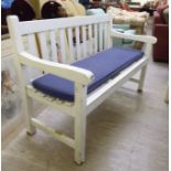 A modern white painted garden bench of slatted construction,