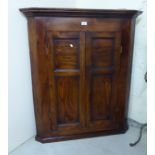 A George III oak hanging corner cabinet with two panelled doors 42''h 36''w BSR