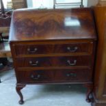 A 1930s mahogany bureau with a fall flap and three long drawers,