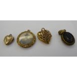 Four dissimilar 'antique' yellow metal lockets: to include one of heart design with floral engraved