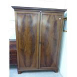 An early 19thC mahogany wardrobe with two panelled doors,