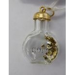 A yellow metal and glass miniature bottle pendant 11