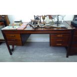 A modern exotic hardwood finished four drawer, twin pedestal desk,