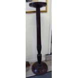 An early 20thC mahogany torchere, the circular top raised on a bulbous,