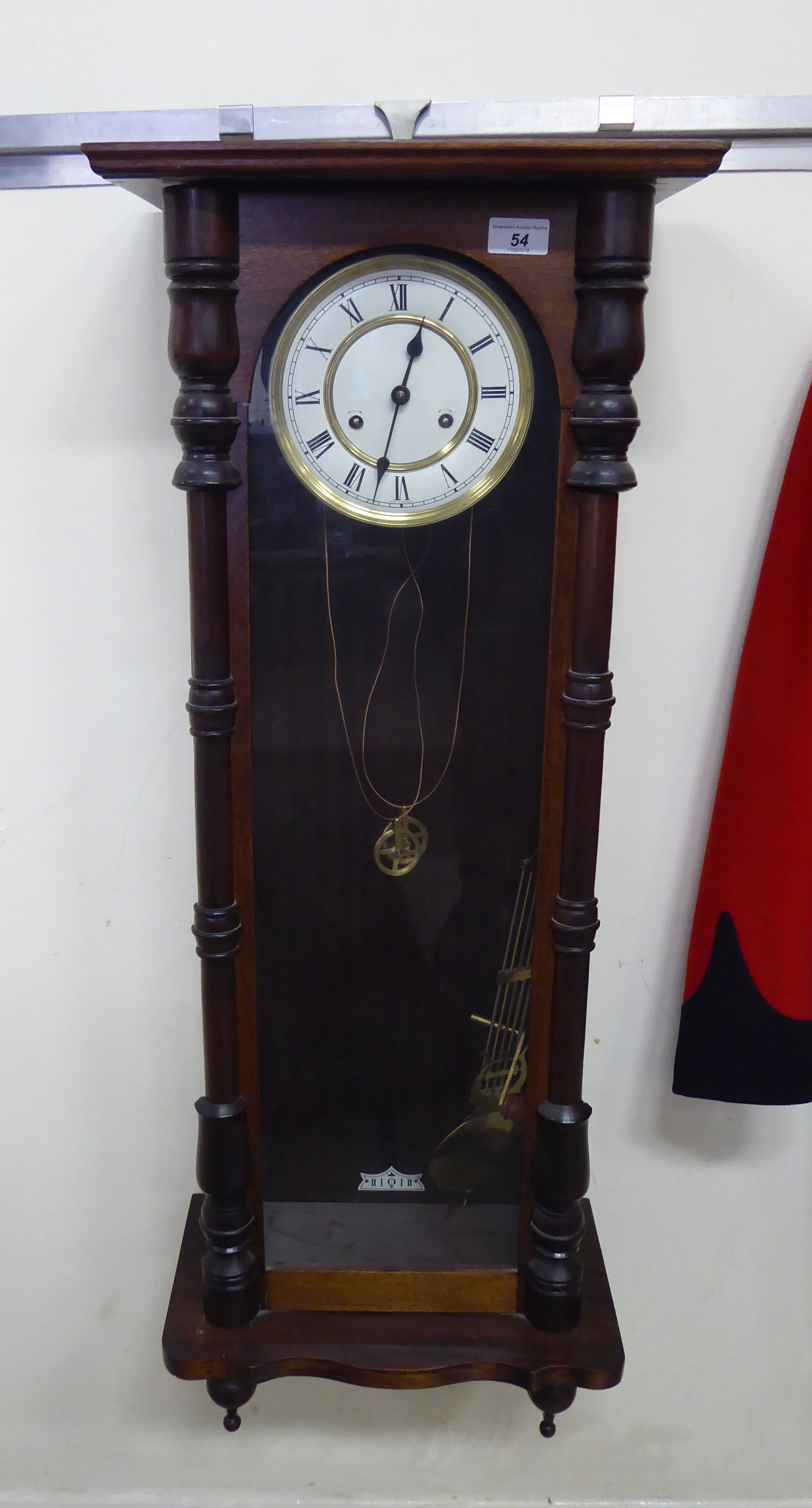 An early 20thC glazed mahogany cased Vienna wall clock with turned pilasters and drop finials;