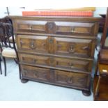 A 1930s Jacobean design oak dressing chest with four graduated long drawers,