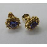 A pair of 14ct gold claw set tanzanite and diamond set earrings 11