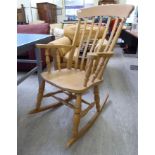 A modern bleached pine rocking chair with a curved crest and lath back,