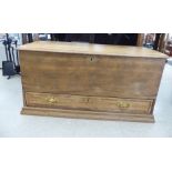 An early/mid 20thC pale oak chest with a hinged lid and straight sides, over a single long drawer,