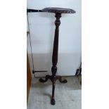A 1920s mahogany torchere stand with a circular dished top, over a reeded column, raised on splayed,