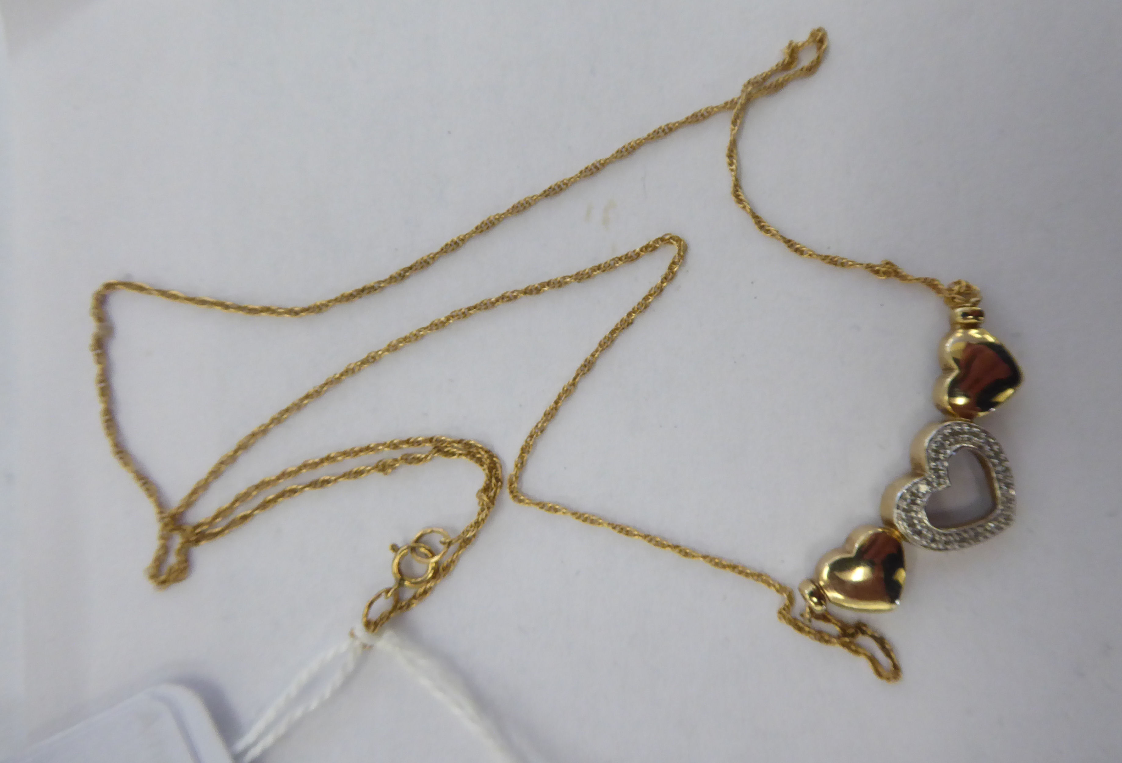 A 9ct gold conjoined, triple heart and diamond set necklet,