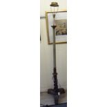 A modern beech standard lamp with a fabric covered column and profusely carved tripod base and
