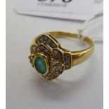 An 18ct gold cluster ring, set with a central emerald,
