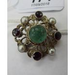 A white metal brooch, set with a green stone,