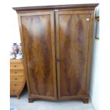 An early 19thC mahogany wardrobe with two panelled doors,