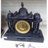 A late Victorian black slate and brass mounted mantle clock of classical architectural design with