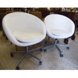 A pair of Ikea moulded tub design chairs, finished in white faux hide,