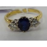 An 18ct gold ring, set with a central sapphire,