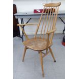 An Ercol beech and elm framed comb back open arm chair,