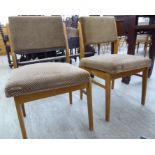 A pair of mid 20thC pine framed dining chairs, the panelled back and seats raised on square,