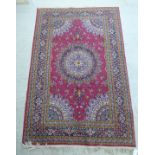 A Persian rug with a central circular motif,
