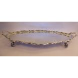 A silver oval tray with a raised piecrust border and opposing bar handles,