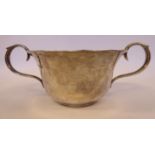 A silver basin with a flared rim and opposing twin,