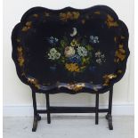 A late Victorian tray table, the serpentine outlined, black lacquered,