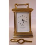 A modern lacquered brass cased carriage timepiece with bevelled glass panels and a folding top