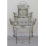 A late Victorian white painted, scrolled wire, three tier,
