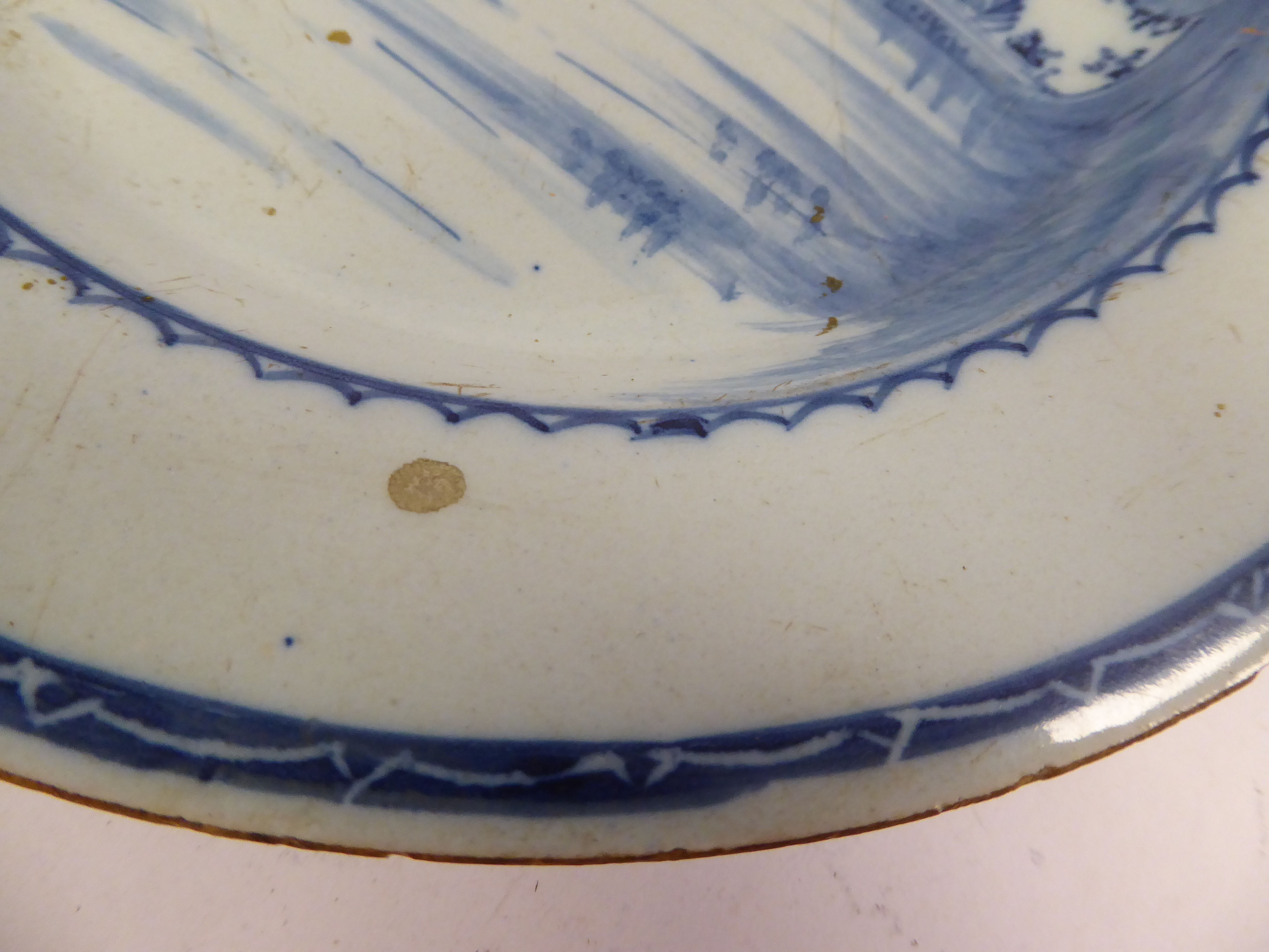 A late 18thC Chinese porcelain broad rimmed plate, decorated in blue and white with a building, - Image 3 of 4