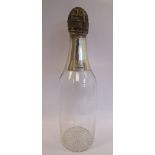 An Edwardian clear glass decanter in the form of a champagne bottle with a star cut base,