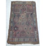 A Caucasian prayer rug, decorated with repeated stylised diamond shaped motifs,