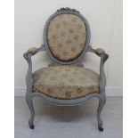 An early 20thC French floral carved, moulded and painted, open arm boudoir chair with an oval,