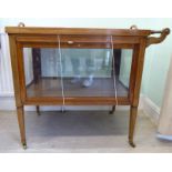 An Edwardian string inlaid mahogany tea trolley with a removeable twin handled tray top over three