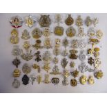 Approx fifty military cap badges and other insignia,