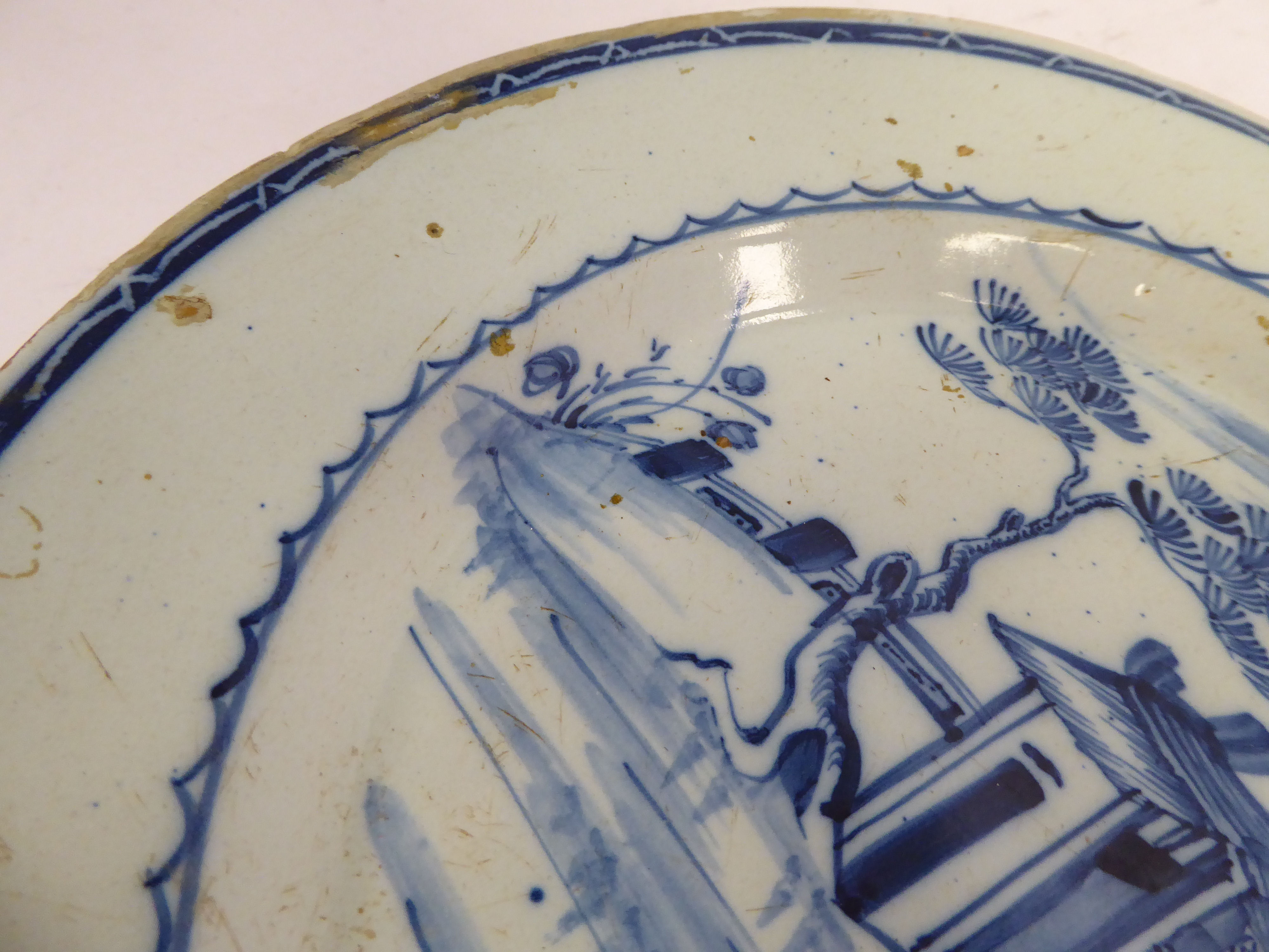 A late 18thC Chinese porcelain broad rimmed plate, decorated in blue and white with a building, - Image 4 of 4