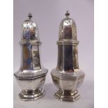 A pair of late Victorian silver casters of octagonal pedestal vase design with perforated domed