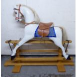 A modern piebald carved and painted wooden nursery rocking horse, on a trestle stand with a mane,