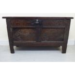 A mid 18thC panelled and carved oak coffer with lunette and lozenge carved ornament, the rising,