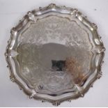 An early Victorian silver salver with a decoratively engraved foliate and scrolled surface and a