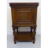 A late 19th/early 20thC Continental oak pot cupboard with a mitred top and a reed carved frieze,