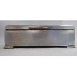 A silver cigarette box with straight sides, a chamfered, hinged lid and engine turned decoration,