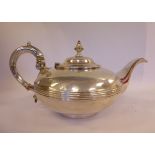 An early Victorian silver footed teapot of squat bulbous form with a reed moulded waistband,
