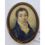 An early 19thC oval head and shoulders portrait miniature, a young man wearing a topcoat and cravat,